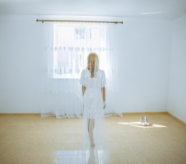 Belle mariée avec voile de dentelle se promène dans la chambre Photo de mariage