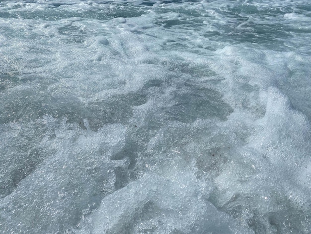 Belle mer avec des vagues éclaboussant de l'eau bleue claire et scintillante chaude dans un oriental tropical chaud