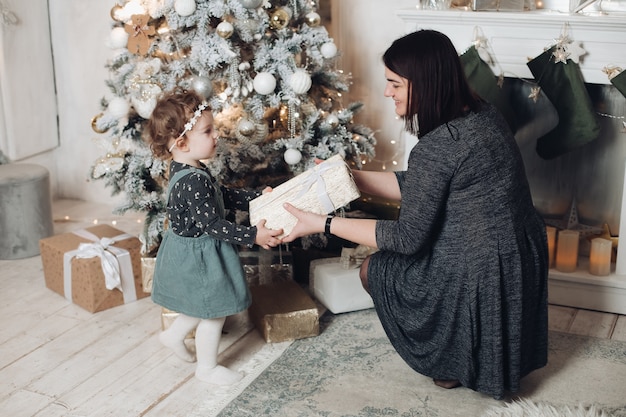 Belle mère donne un cadeau à sa jolie jeune fille à la maison