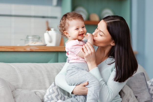 Belle mère embrasse un bébé souriant heureux