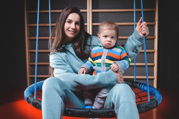 Belle mère avec un enfant charmant s'amusent dans un parc d'attractions