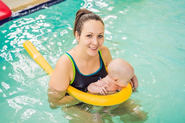 Belle mère enseignant à une jolie petite fille comment nager dans une piscine Enfant s'amusant dans l'eau avec maman