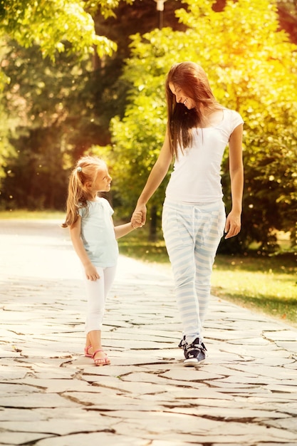 Belle mère et fille marchant dans un parc le jour du printemps.