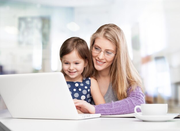 Belle mère et jolie fille utilisant un ordinateur portable