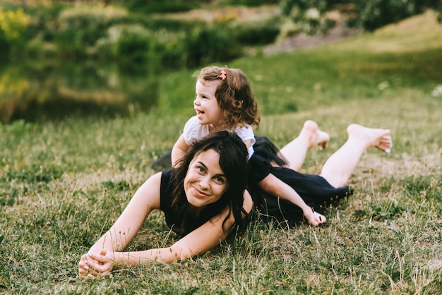 Une Belle Mère Jouant Pieds Nus Sur L'herbe Avec Sa Jolie Fille En été Ensoleillé