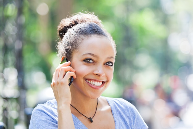 Belle métisse jeune femme parlant au téléphone mobile