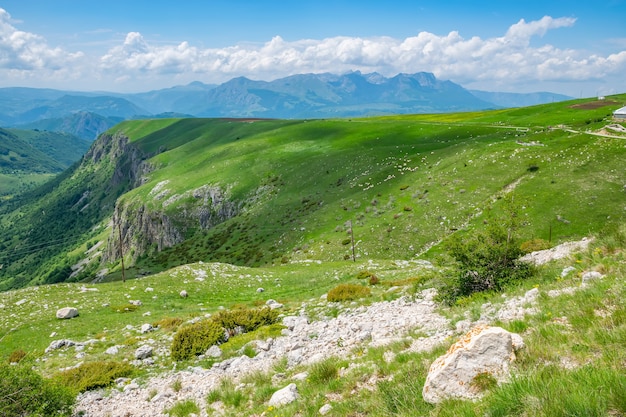 Belle montagne d'herbe verte avec des nuages blancs dans le ciel bleu