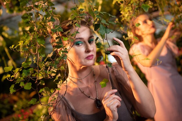 Belle Nature. Belle Jolie Femme Vous Regarde Tout En Touchant Une Branche D'arbre