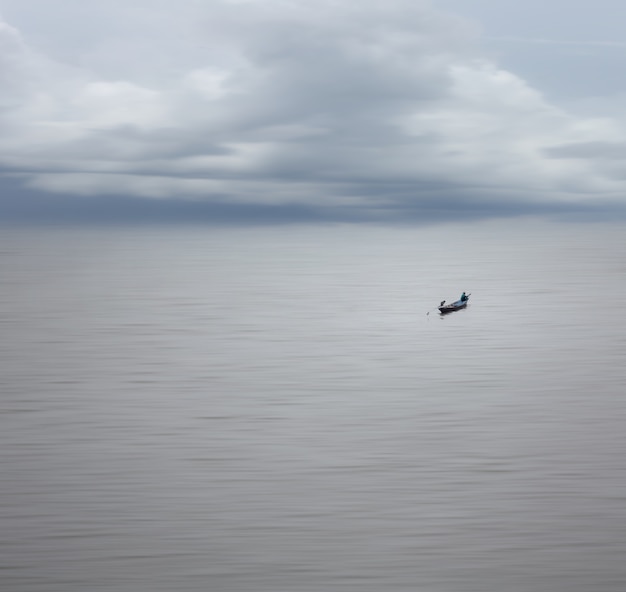 Belle Nature Avec Une Longue Distance De Pêcheur Sur Le Bateau Dans Une Mer Douce Et Un Ciel Clair, Effet De Flou De Mouvement Et Minimalisme.