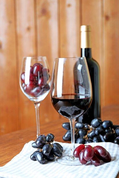 Belle nature morte avec du vin et du raisin sur une table en bois