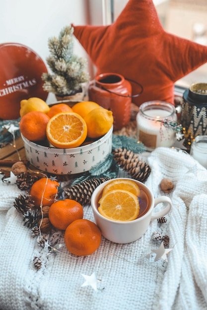 Belle nature morte de Noël Une tasse de thé chaud avec un sixième plaid tricoté sur le rebord de la fenêtre avec un décor du Nouvel An