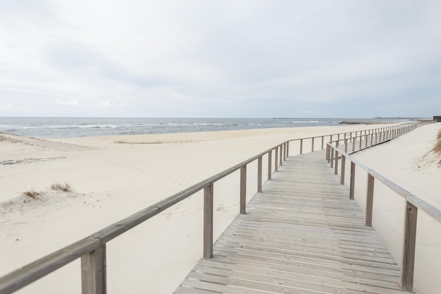 Belle passerelle en bois sur la plage le long de l'océan