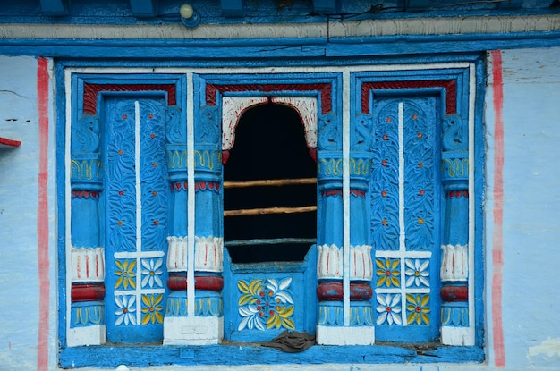 Photo la belle peinture sur bois dans la fenêtre d'une vieille maison du village rural