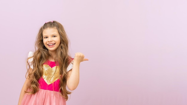 Une belle petite fille aux cheveux bouclés pointe son doigt vers l'annonce.