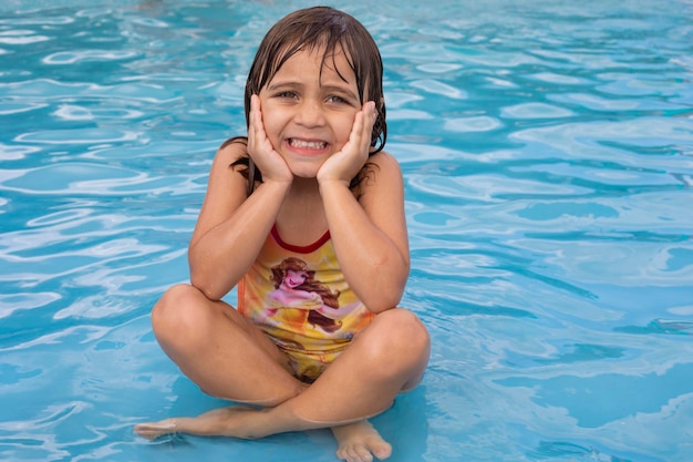 Belle petite fille caucasienne dans la piscine rafraîchissante en été