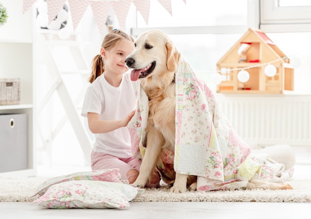 Belle petite fille couvrant un chien mignon