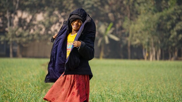 Photo une belle petite fille dans la campagne du bangladesh danse heureuse dans le champ une belle petite fille modèle dans le pays d'asie du sud du bangladesh