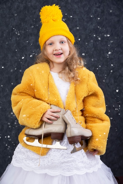 Une belle petite fille dans un chapeau jaune tricoté