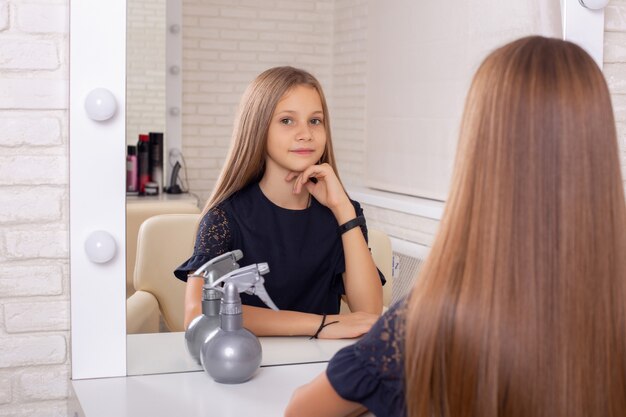 Belle petite fille dans un salon de coiffure