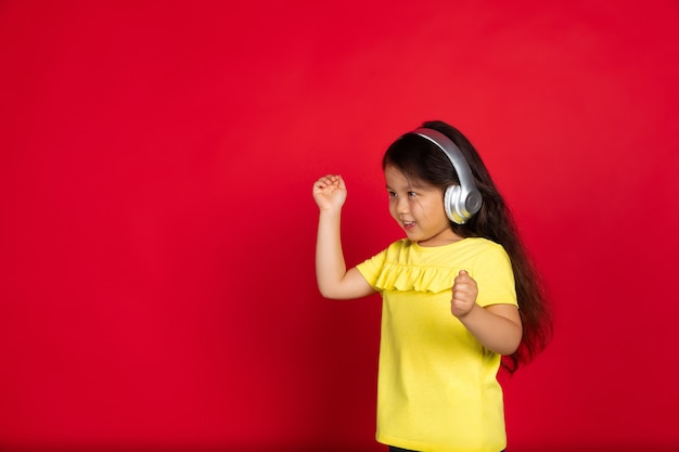 Belle petite fille émotionnelle isolée sur fond rouge