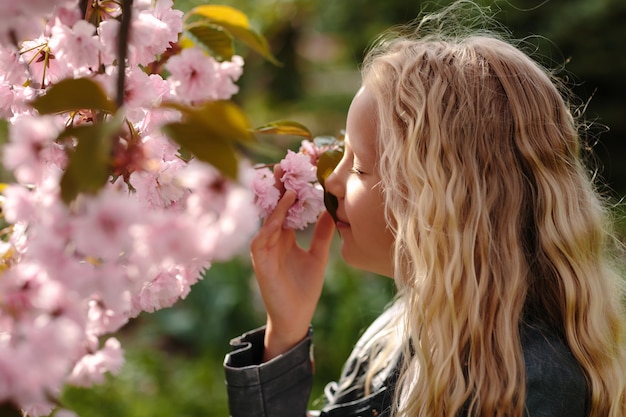 Belle petite fille enfant avec des fleurs de sakura