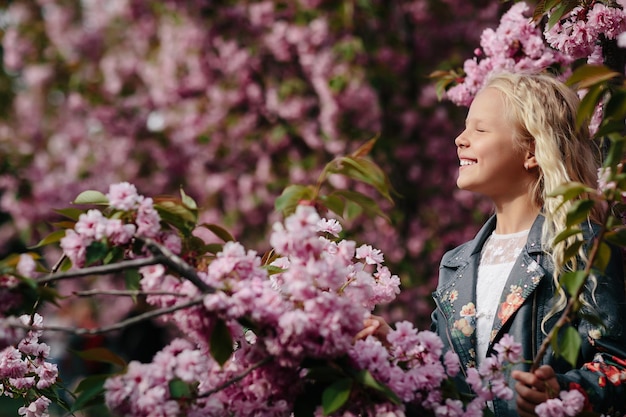 Belle petite fille enfant avec des fleurs de sakura