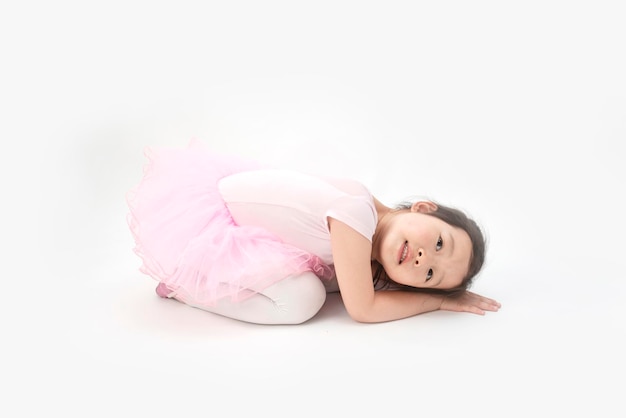 La belle petite fille fait de la gymnastique sur fond blanc