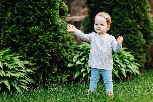 Belle petite fille avec une fleur sur sa tête à l'extérieur en journée ensoleillée.