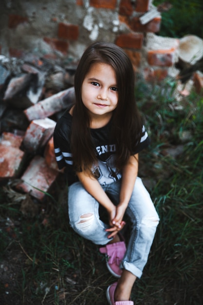 Belle petite fille en jeans déchiquetés.