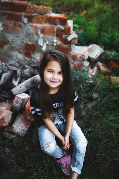 Belle petite fille en jeans déchiquetés.