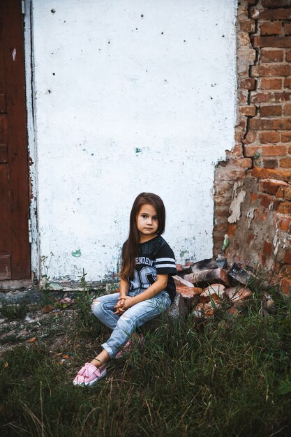 Belle petite fille en jeans déchiquetés.