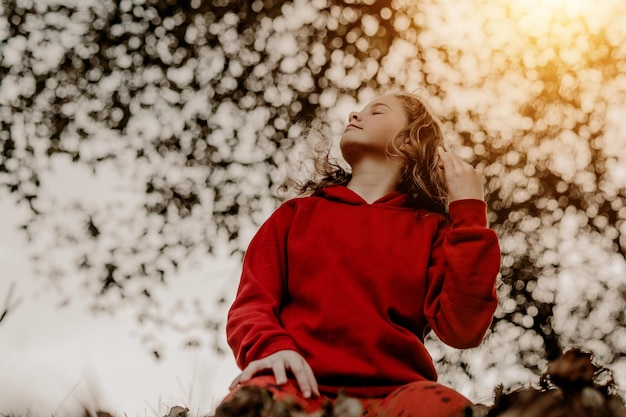 Une belle petite fille jouant dans les feuilles à l'automne