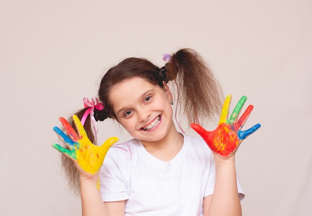 Belle petite fille avec les mains dans la peinture