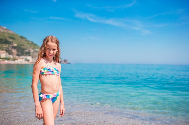 Belle petite fille à la plage s'amuser