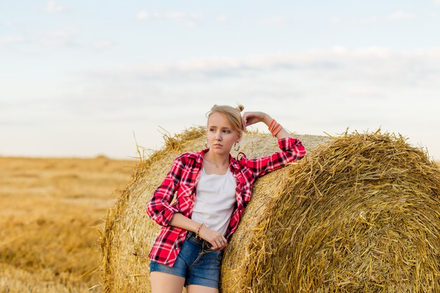 Belle petite fille près d'une paille dans le domaine