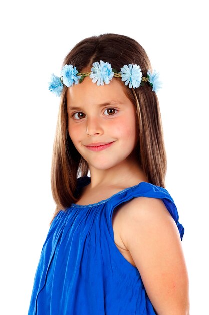 Belle petite fille avec une robe bleue et une couronne de fleurs sur la tête