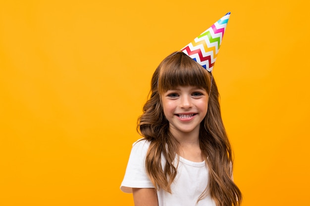 Belle petite fille en robe isolée sur jaune ou orange