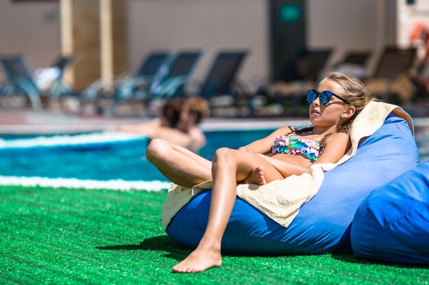 Belle petite fille s'amuser près d'une piscine extérieure