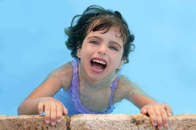 Belle petite fille souriante dans la piscine