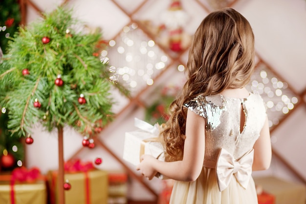 Belle petite fille tenant une boîte-cadeau de Noël