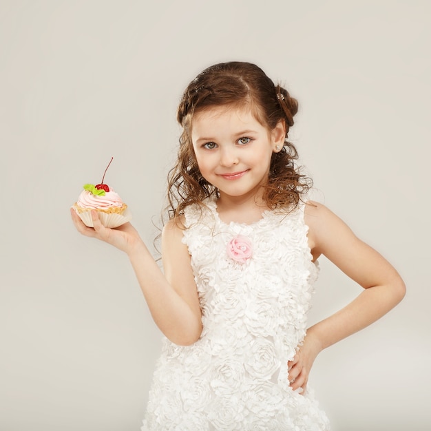 Belle petite fille tenant un délicieux gâteau appétissant à la cerise