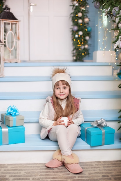 Belle petite fille sur une terrasse décorée pour Noël