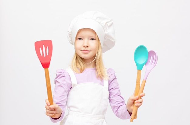 Belle petite fille en uniforme de chef isolé sur blanc