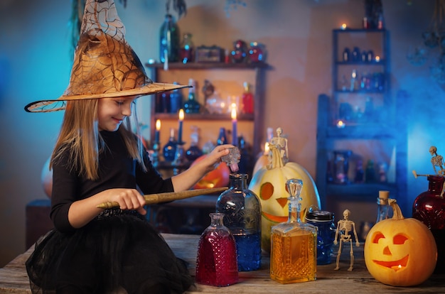 Belle petite sorcière avec des décorations d'Halloween