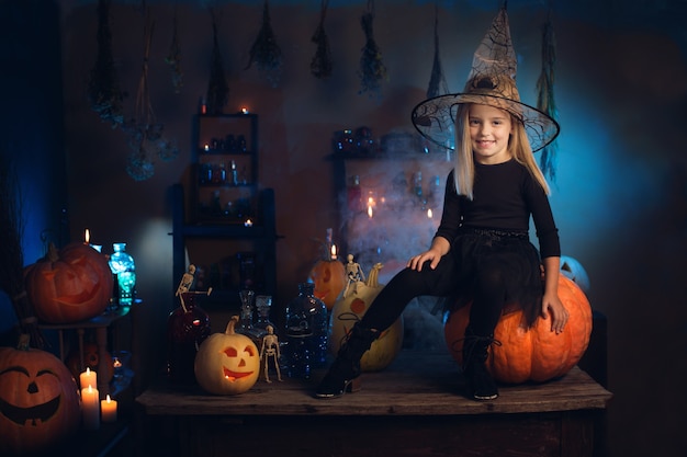 Belle petite sorcière avec des décorations d'Halloween