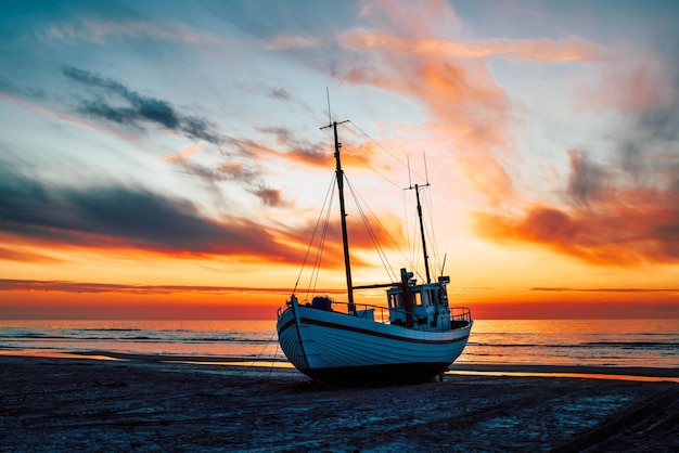 Belle photo d'un bateau sur un fond de coucher de soleil pittoresque