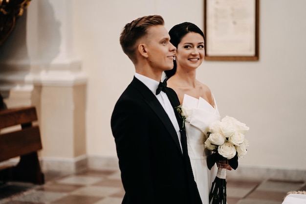 Belle photo d'une mariée et d'un marié blancs caucasiens ensemble dans l'église en Lituanie