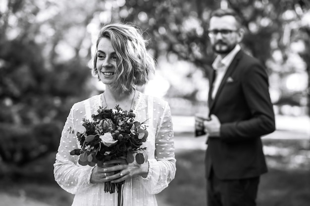 Belle photo en noir et blanc de la mariée et du marié Heureux couple posant et souriant en robe de mariée