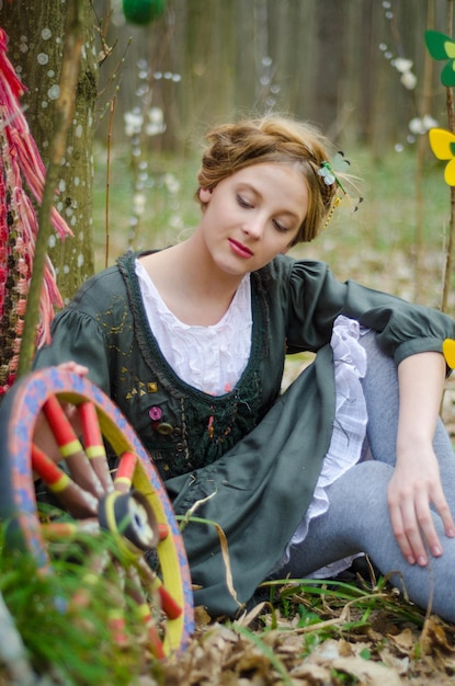 Belle photo de style rétro d'une fille près d'une roue vintage