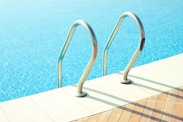 Une belle piscine avec des balustrades brillantes sous la lumière du soleil.